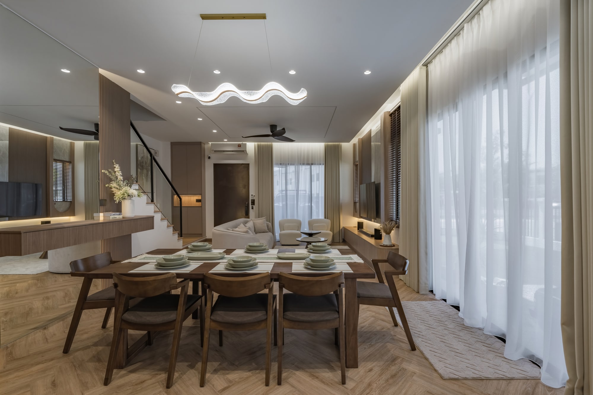 Ruang makan dan ruang tamu terbuka Myra Alam di Puncak Alam dengan kemasan kayu dan cahaya semula jadi