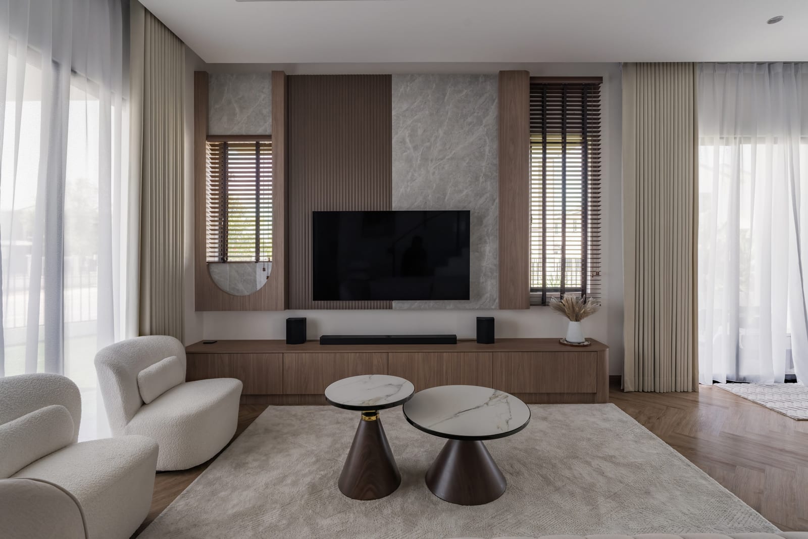 Ruang tamu dengan sofa rendah, meja kopi berpasangan dan dinding televisyen berpanel kayu untuk Myra Alam Residences di Puncak Alam — fotografi projek